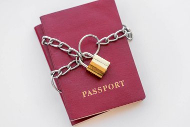 Beyaz zemin üzerinde altın bir kilidi ile zincir sarılı kırmızı pasaport