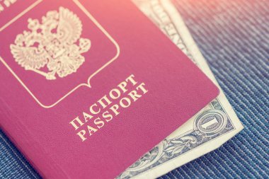 1 Rus pasaportu bir mavi Tekstil arka planda güneş ışığı altında yatan dolar. Tonda
