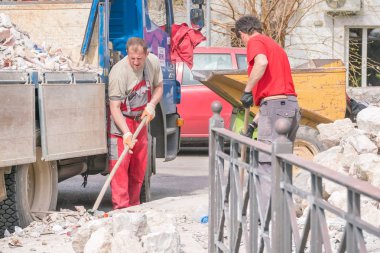 Kotor, Karadağ, 28 Nisan 2017: Erkekler kürek ile inşaat çöp bir kamyona yüklemek