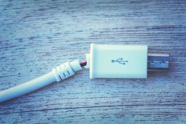 Ahşap bir masa üzerinde kırık usb kablosu. Tonda