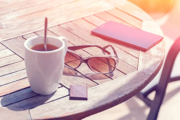 Mesa Redonda Madera Con Una Taza Gafas Sol Pedazo Chocolate —  Fotos de Stock