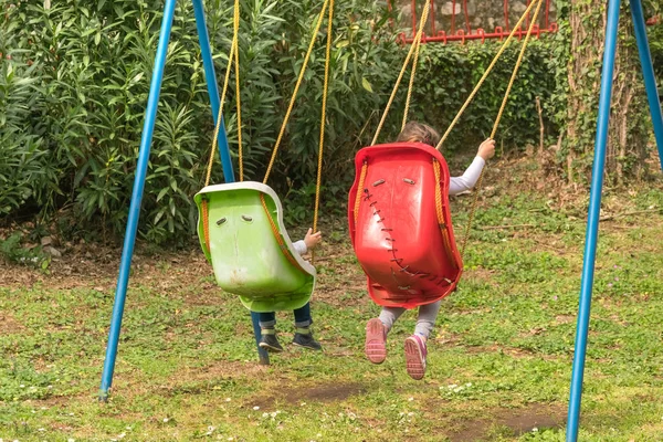 Kinder Reiten Auf Einer Alten Plastikschaukel Garten Rückansicht — Stockfoto