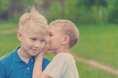 Mavi tişört arkadaşı kulakta sarışın çocuk konuşuyor