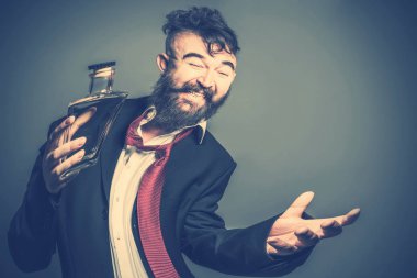Takım elbise ve kravat kırmızı sakallı bir adam bozuk görüntü alkol elinde bir şişe ile. Tonda