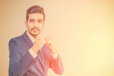 Yumruk jest güneş ışığında gösterilen mavi elbiseli Genç çekici adam. Tonda