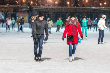 Kazan, Rusya, 22 Ocak, 2017: erkek ve kadın akşamları buz pateni pisti üzerinde kırmızı ceketli