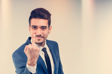 Mavi takım gösteren orta parmak genç çekici adam. Tonda