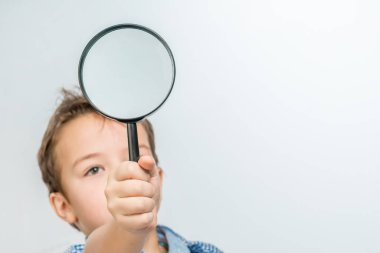 Mavi gömlekli bir büyüteç ile sevimli çocuk