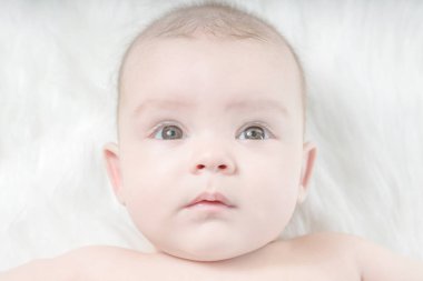 Üzgün bebek üzerinde beyaz bir kürk yalan