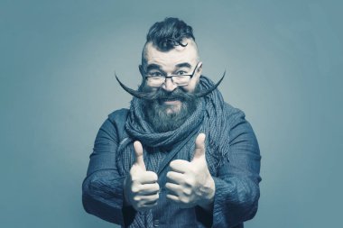 Yetişkin başparmak gri bir arka plan üzerinde gösterilen çok uzun bıyıklı adam sakallı. Tonda