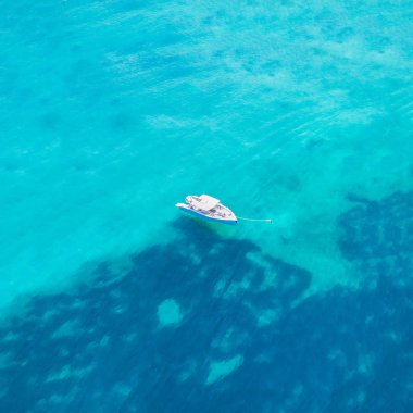 Mavi denizin içinde bir teknede yatan bir adam üstten görünüm