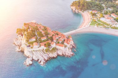 Bir ada güneş ışığı altında binaları ile üstten görünüm