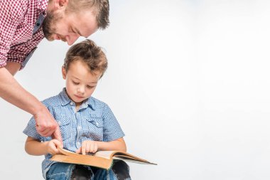 Adam ve çocuk beyaz bir arka plan üzerine bir kitap okuma