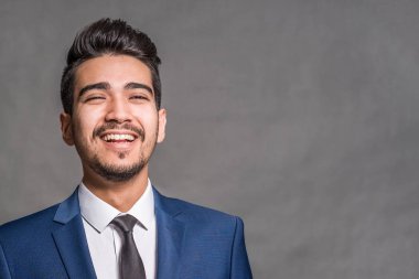 Gri bir arka plan üzerinde mavi elbiseli Genç çekici adam