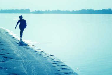 Günbatımında sörf hat boyunca çalışan kız Genç