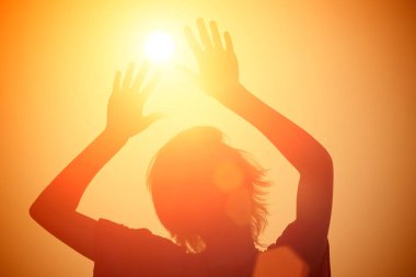 Bir kız güneşe kaldırdı elleriyle silüeti
