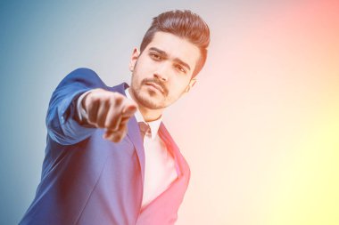 Bir parmak ileri parlak ışıkta gösterilen mavi elbiseli Genç çekici adam