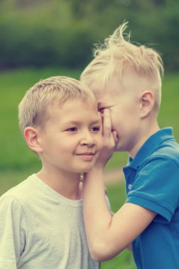 Gülen çocuk arkadaşı kulakta konuşurken