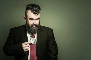 Yetişkin yeşil arka plan üzerinde bir dolar tutan elbiseli adam sakallı