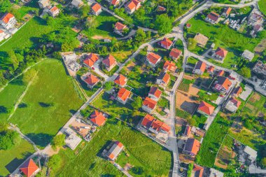 Üstten görünüm grubunun yeşil çimenlerin üzerinde kırmızı kiremitli çatılı evler