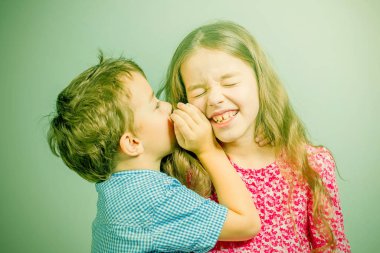 Çocuk bir kız kulağına konuşuyor