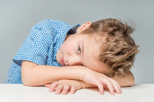 Lindo Chico Una Camisa Azul Mesa Sobre Fondo Gris Aislado — Foto de Stock