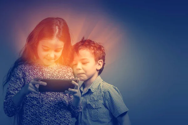 Niedliche Mädchen Und Jungen Die Dunkeln Das Leuchtende Telefon Schauen — Stockfoto