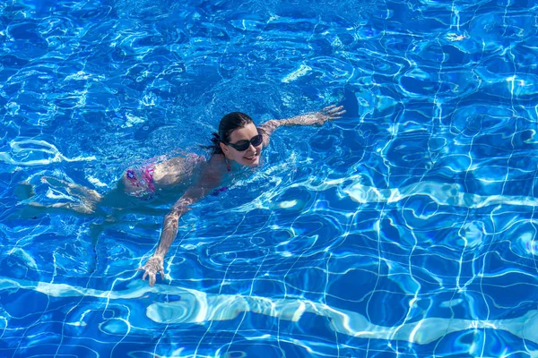 Bikini Güneş Gözlüğü Esmer Kadın Havuzda Yüzüyor — Stok fotoğraf