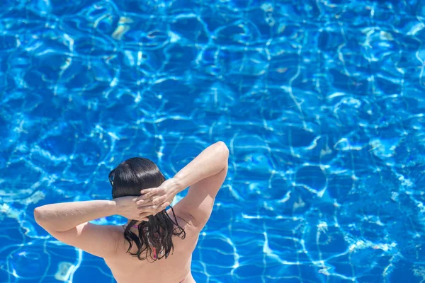 青い水プールの背景にブルネットの女性 — ストック写真