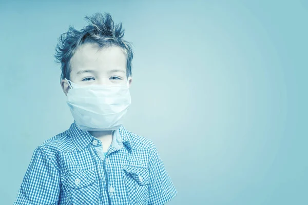 Niño Con Una Máscara Médica Cara Sobre Fondo Azul Tonificado —  Fotos de Stock