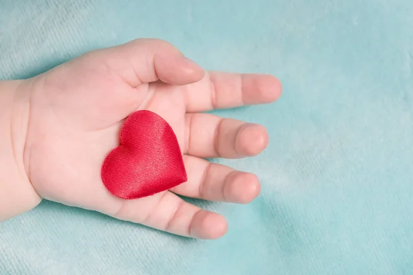 Rotes Herz Der Hand Eines Babys Auf Blauem Hintergrund — Stockfoto