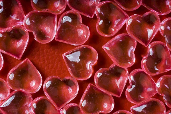 Прозрачные Стеклянные Сердца Красном Кожаном Фоне — стоковое фото