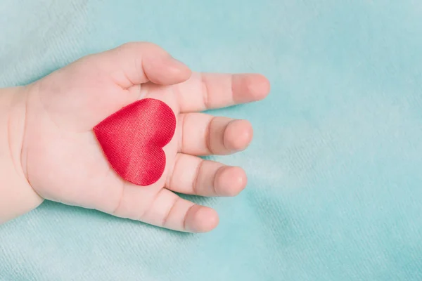 Rotes Herz Der Hand Eines Babys Auf Blauem Hintergrund — Stockfoto