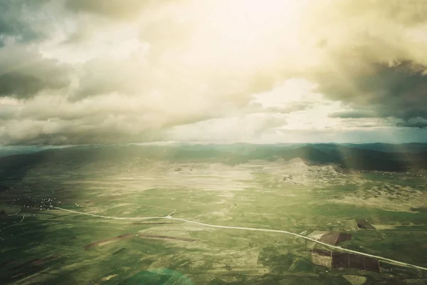 Top view of a mountain valley and asphalt road in the sunlight