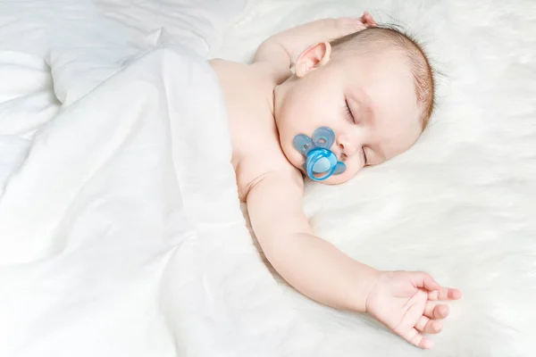 Niedliches Baby Schläft Auf Weißem Flauschigem Hintergrund Mit Blauem Schnuller — Stockfoto