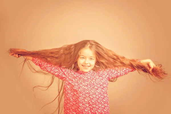 Linda Niña Vestido Rojo Tirando Del Pelo Largo Diferentes Direcciones —  Fotos de Stock