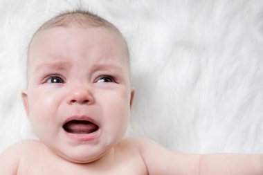 Kabarık beyaz bir arka plan üzerinde Ağlayan bebek