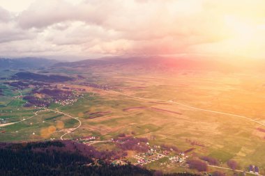 Güneş ışığı altında dağlarda bir köyün üstten görünüm