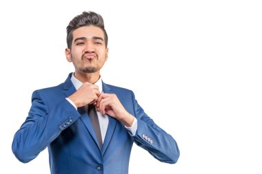 Mavi elbiseli Genç çekici adam beyaz bir arka planda kravat düzeltir. İzole