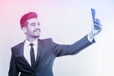 Telefonun ekranına bakarak mavi elbiseli Genç çekici adam. Tonda