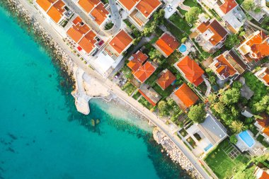 Resort kıyı kenti. Evler deniz kenarında kırmızı kiremitli çatılar ile görüntülemek yukarıdan
