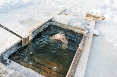 Adam dalış Epifani Bayramı bir buz deliğe