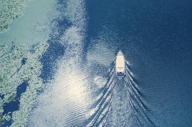 Su üzerinde yüzen tekne ile yeşil yosun kaplı