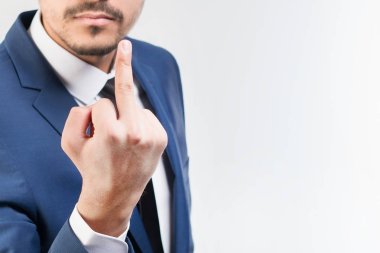 Mavi takım gösteren orta parmak gri bir arka plan üzerinde genç çekici adam. İzole