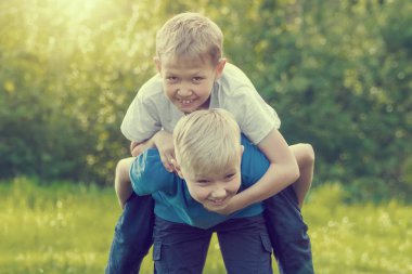 Çocuk parkta bir arkadaşına sırtını atlama