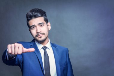 Mavi takım başparmak mavi bir arka plan üzerinde genç çekici adam