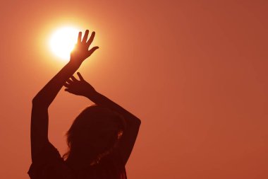 Bir kız güneşe kaldırdı elleriyle silüeti