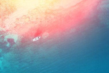 Güneşli bir günde denizde yüzen bir beyaz teknenin üstten görünüm