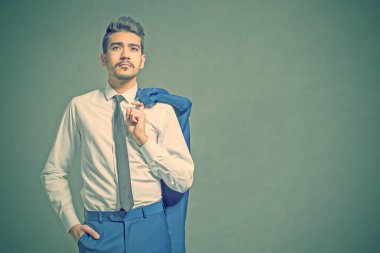 Çekici genç bir beyaz gömlek, kravat ve ceket omzunda asılı. Tonda