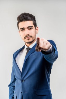 Bir parmak ileri gri bir arka plan üzerinde gösterilen mavi elbiseli Genç çekici adam. İzole